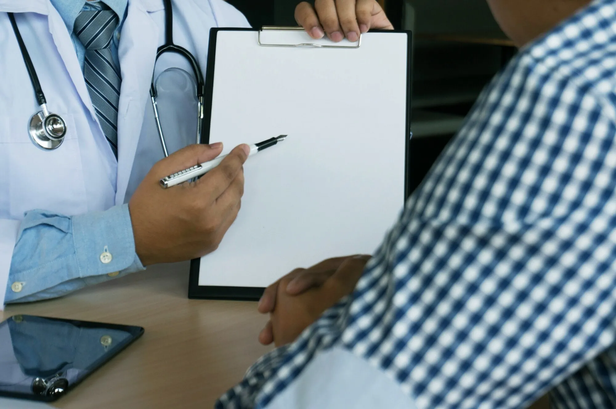 Close up de paciente e médico tomando notas ou Médico profissional em entrevista de revestimento de vestido de uniforme branco