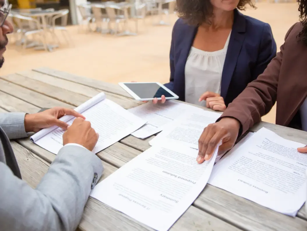 Profissionais analisando documentos de um processo sobre a mesa